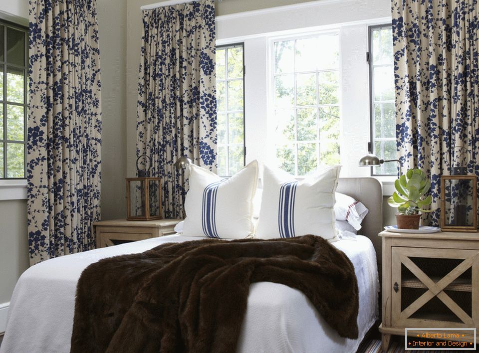 Modré květy na záclonách a pruzích na polštářích jsou harmonicky kombinovány ve vnitřku ložnice