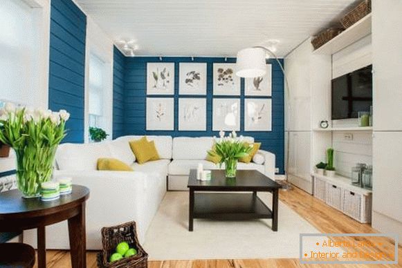 Bílá pohovka v interiéru s modrou tapetou a dřevěnou podlahou
