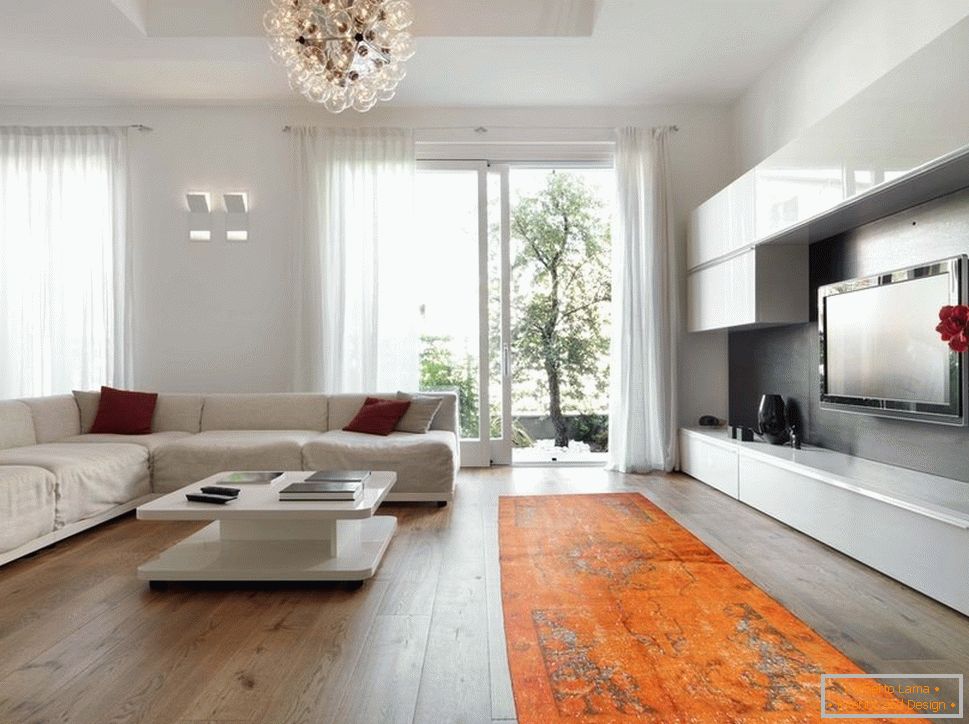 Oranžový koberec v kombinaci s bílým nábytkem a zdmi