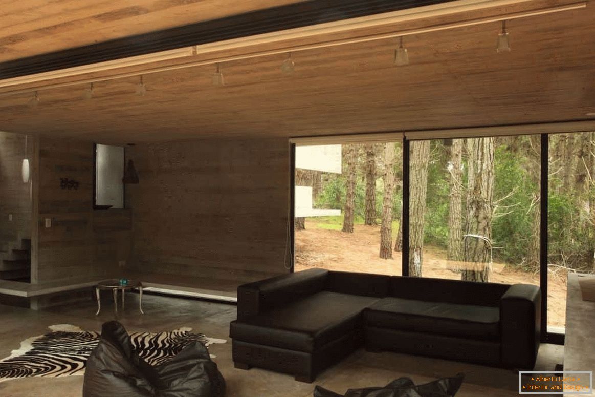 Obývací pokoj s dřevěným nábytkem v dřevěném domě s panoramatickým oknem