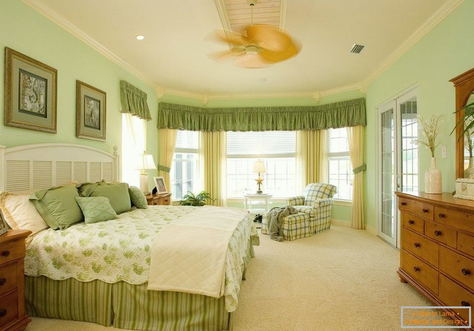 Interiér prostorné ložnice v zelené barvě