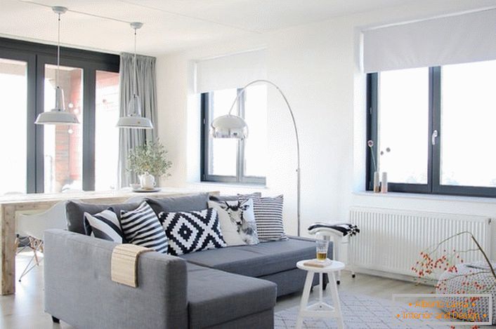 Skandinávská země v designu malého městského domu. V moderním obývacím pokoji je hrubý dřevěný stůl. 