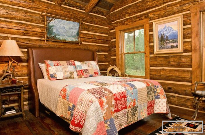 Pokoj v rustikálním stylu v loveckém chatě. Pozoruhodná dekorace zdí s pomocí dřevěného domu. 