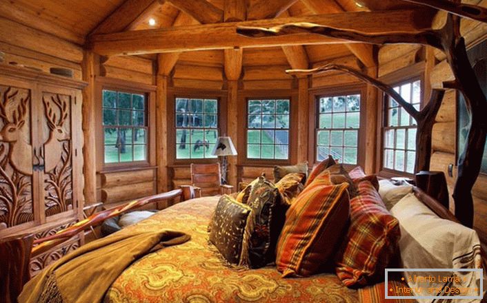 Jedna z ložnic v domě u jezera je vyrobena ve stylu venkovské krajiny. Dřevěná dekorace. Masivní nábytek a dekorativní prvky jsou vybírány v nejlepších tradicích stylu.