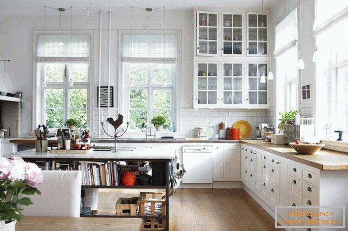 Prostorná kuchyň ve skandinávském stylu by měla být co nejmenší. Prioritou je denní světlo, takže kuchyň je vybavena velkými okny s dřevěnými rámy. 