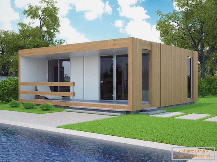 Malý modulární dům s bazénem ve dvoře. Stylový design domu, který je postaven rychle, vypadá organicky na pozadí krátkého oříznutého trávníku.
