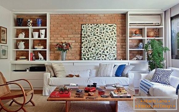 Interiér obývacího pokoje s cihlovou stěnou a bílým nábytkem