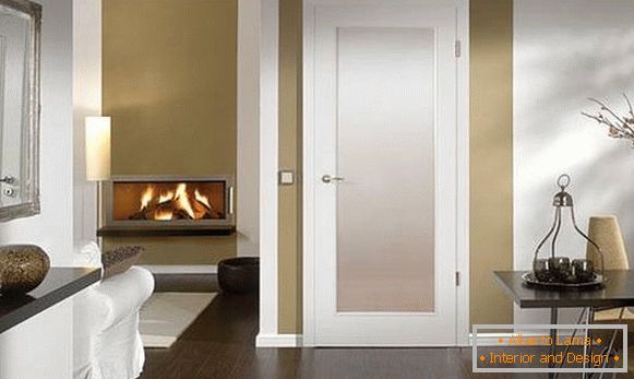 Bílé dveře v interiéru obývacího pokoje s hnědou podlahou