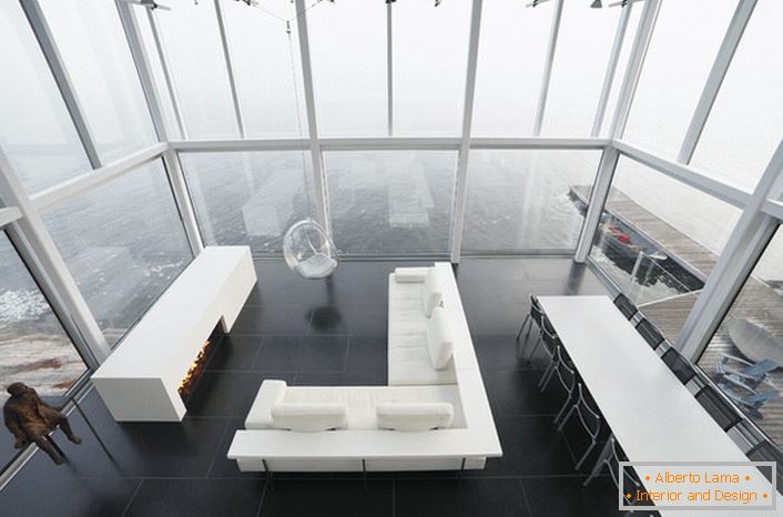 Laconický design obývacího pokoje v minimalistickém stylu. Zajímavým nábytkem je židle zavěšená z vysokého stropu.