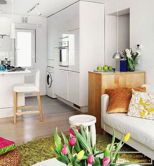Bílá kuchyně v obývacím pokoji malého bytu ve Španělsku