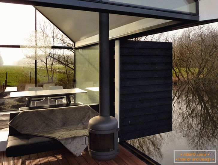 Terasa malého skleněného domu u jezera v Holandsku