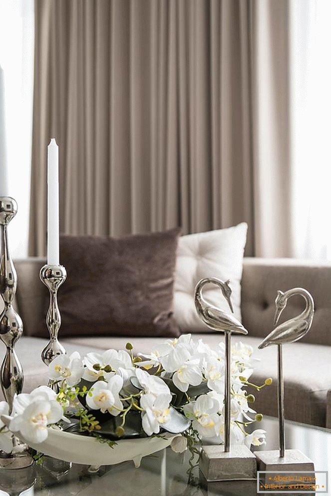 Složení orchidejí, svíček a dalších dekorativních prvků na stole v obývacím pokoji