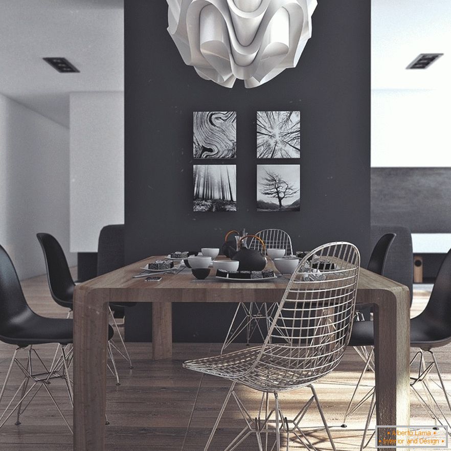 Dřevěný jídelní stůl, černé židle a originální obrazy na černé stěně