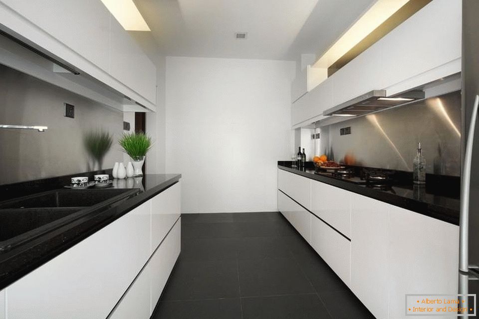 Úzká a dlouhá bílá kuchyně s černou podlahou