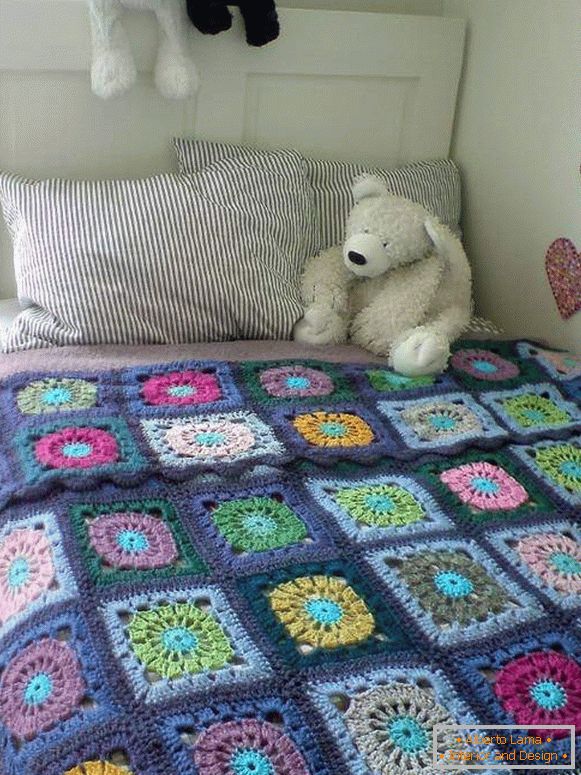 Pletené přikrývky na posteli v dětském pokoji ve stylu patchwork