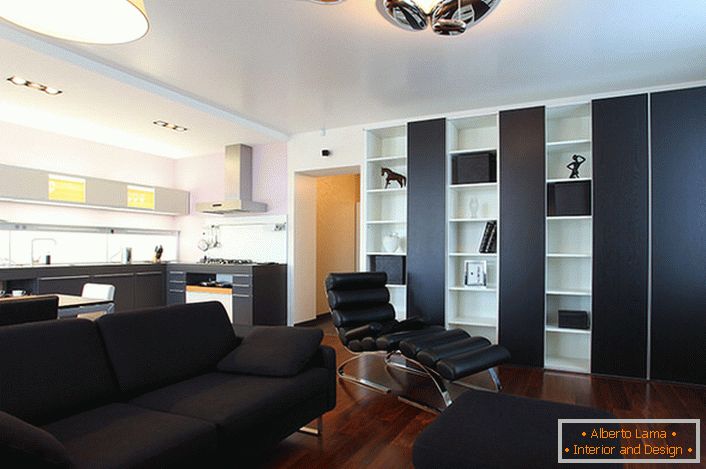 Černá pohovka, která se skládá z polštářů a malého osmanského nábytku, se vyrábí na zakázku pro interiérovou výzdobu v high-tech stylu.
