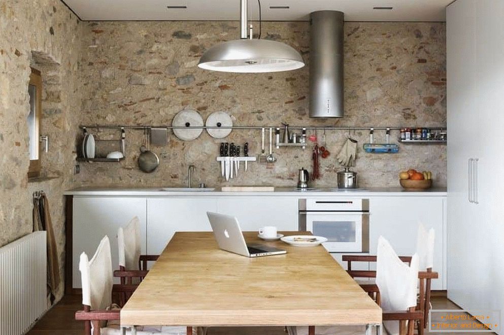Kuchyně s betonovými stěnami a velkou šatní skříní s jídelním koutem