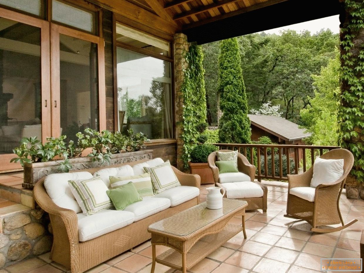 Dřevěný nábytek s bílými polštáři na verandě