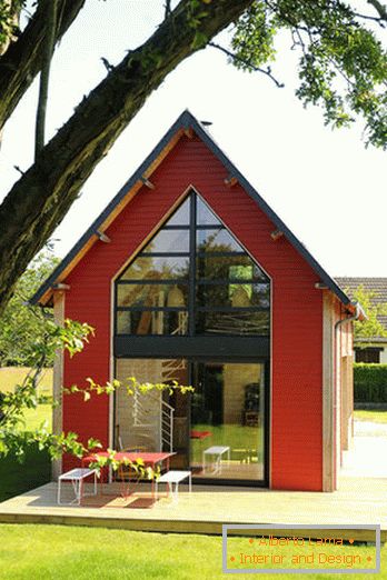 Interiér malého dřevěného domu s velkými okny