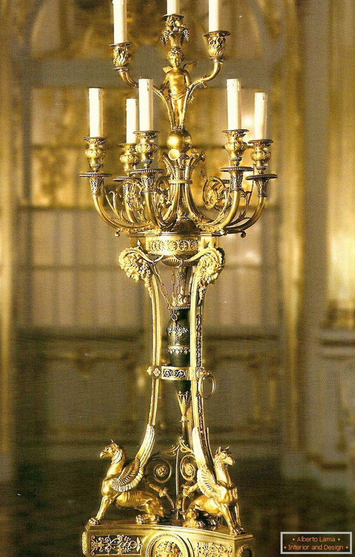 Vznešená, rafinovaná zlatá svícen pro devět svíček vyzdobí interiér nějakého venkovského domu nebo loveckého kláštera.