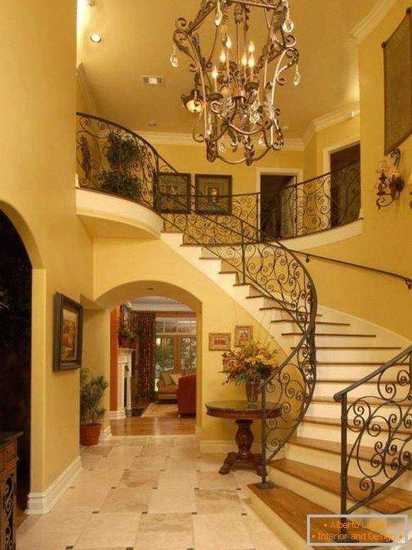 Velký kovaný lustr před schody v chodbě