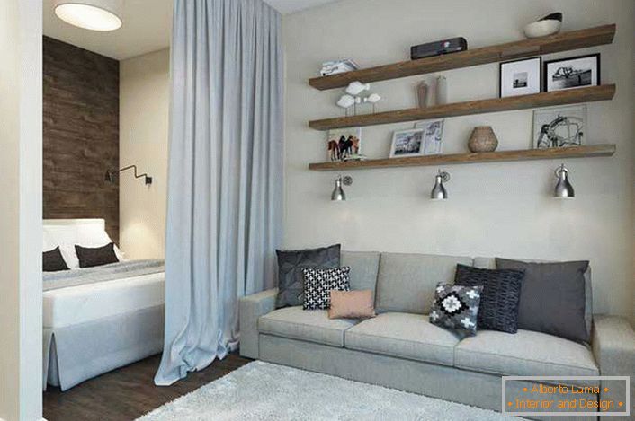 Designové uspořádání studiového bytu o rozloze 40 m2 rozděluje prostor na obývací pokoj a ložnici. Místo pro odpočinek je pokryto těžkou těžkou záclonou. 