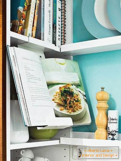 Knihy a nádobí v malé kuchyni v tyrkysové barvě