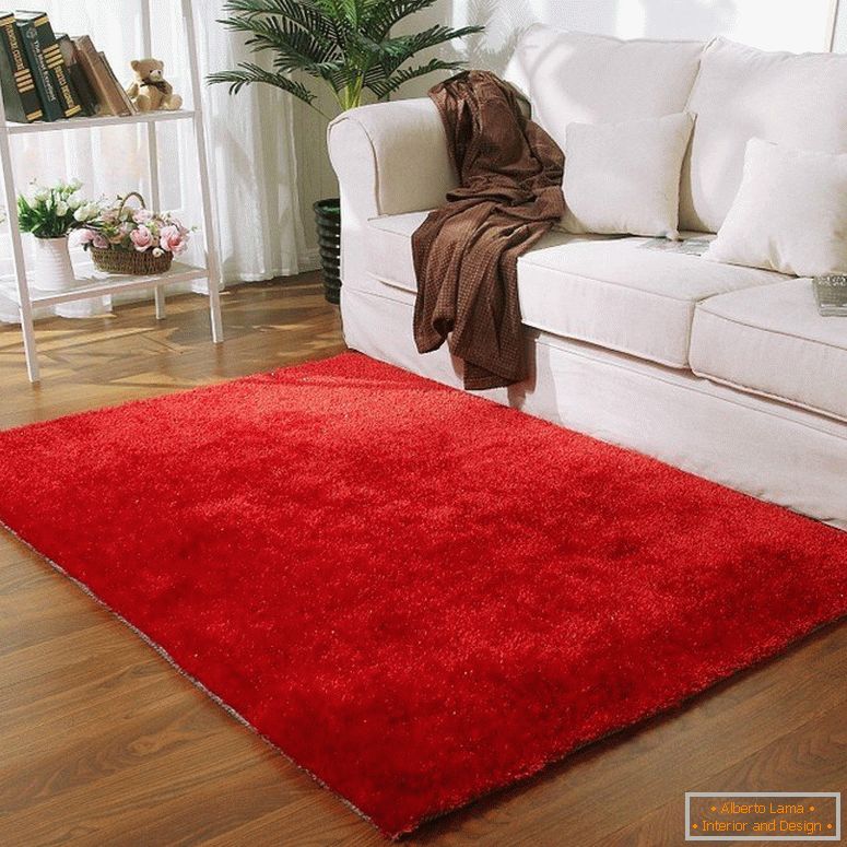 Červený koberec před bílou pohovkou