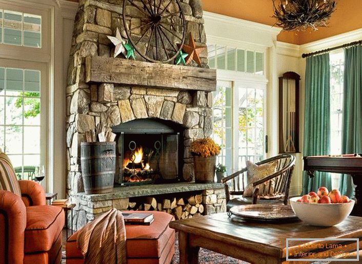 Prostorný pokoj pro hosty ve venkovském domě ve venkovském stylu. Pozoruhodné jsou velká okna s dřevěnými rámami a obrovským krbem z přírodního kamene.