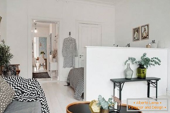 Rozdělení mezi obývacím pokojem a ložnicí v apartmánu ve skandinávském stylu