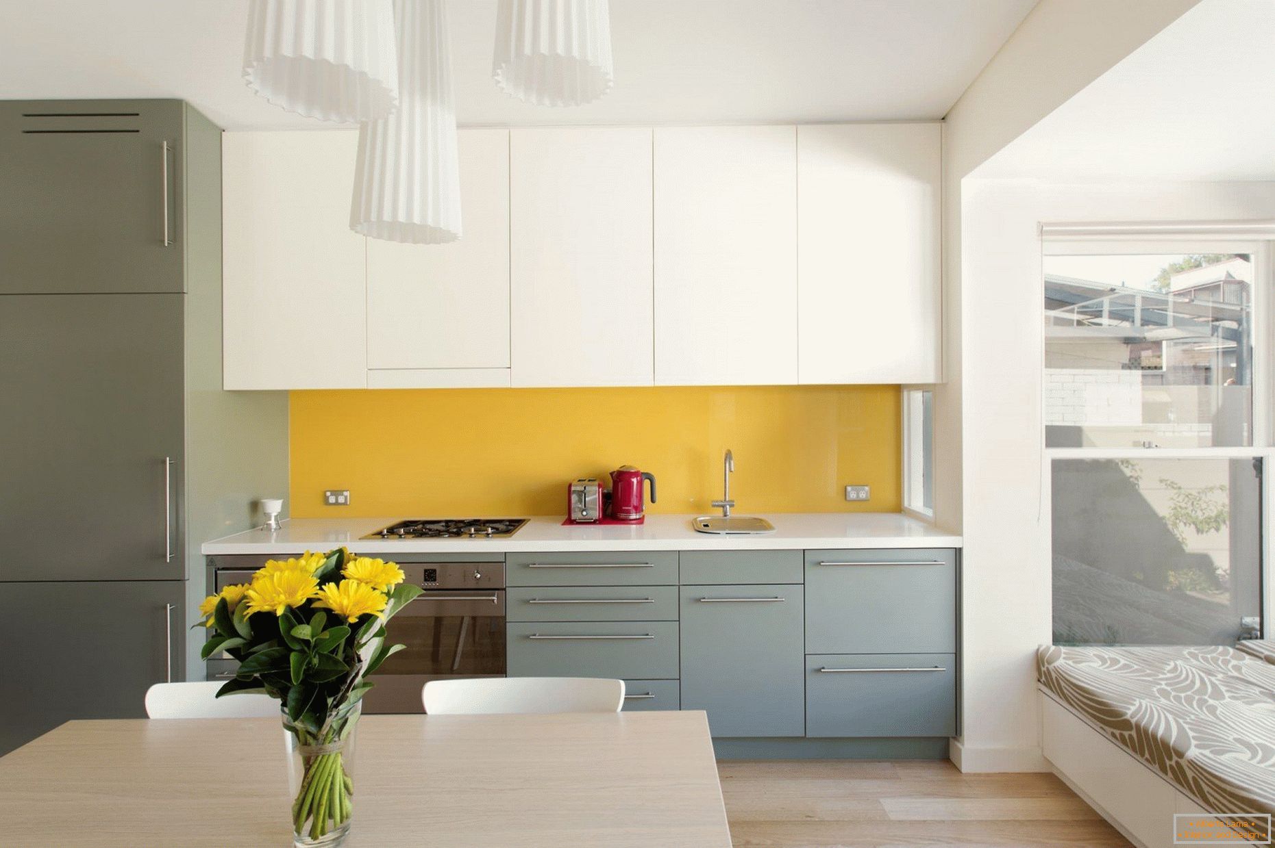 Žlutá zástěra v bílé a šedé kuchyni