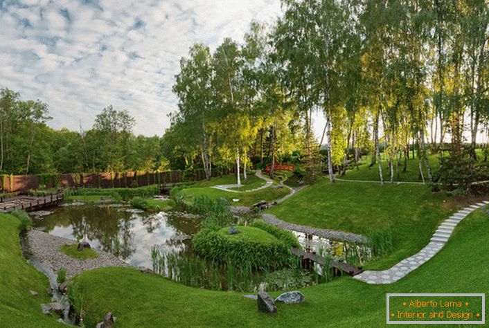 Umělý rybník za domem, zdobený ve stylu chaty. Neobvyklé, odvážné řešení pro návrh krajinného designu.
