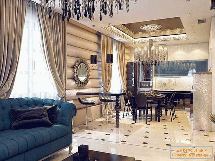 Pompézní interiér studiového apartmánu ve stylu Art Deco je vyzdoben těžkými závěsy z husté tkaniny a stropním lustrem s obrovským množstvím malých, tenkých řetězů. 