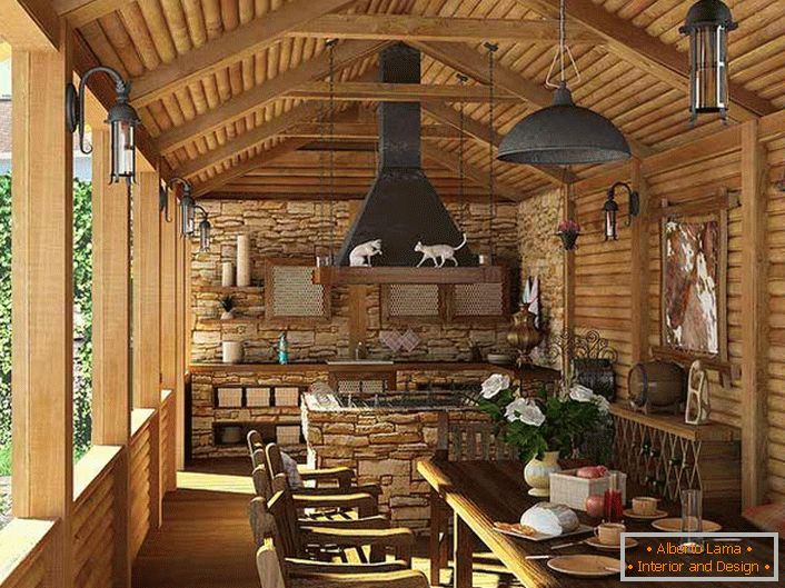 Malá kuchyně s grilem na verandě venkovského domu. Styl země je doložen především dekorem stěn a stropů s dřevěným rámem.