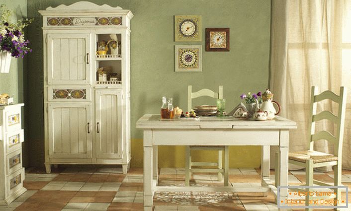 Útulná kuchyně ve venkovském stylu je provedena v bílém a jemném olivovém světle. Perfektní kombinace barev pro rustikální styl.