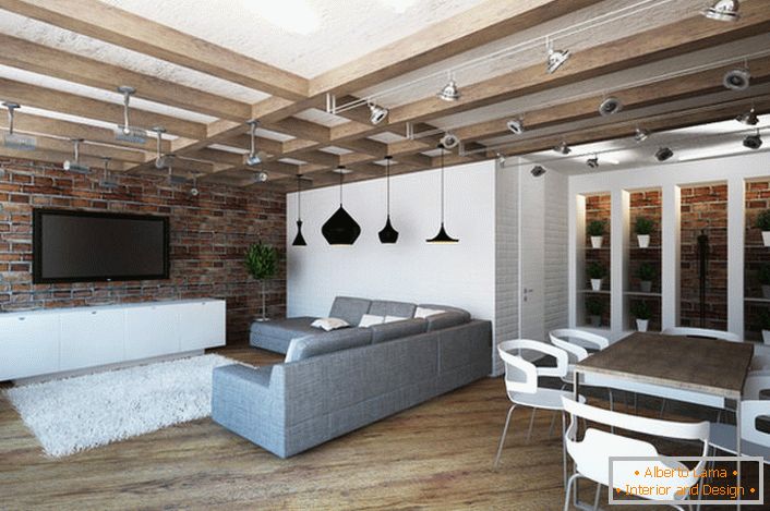 Prostorný obývací pokoj ve stylu podkroví je pozoruhodný pro správně uspořádaný prostor, který je podmíněně rozdělen na jídelnu a odpočinkovou plochu.