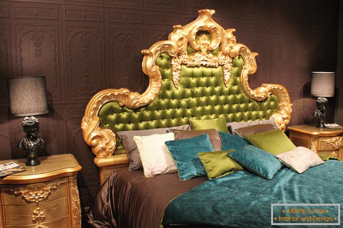 Vysoká ozdobná záda v hlavě postele je pokryta olivovým hedvábím. Zajímavé polštáře kontrastních barev a přehozů na posteli.