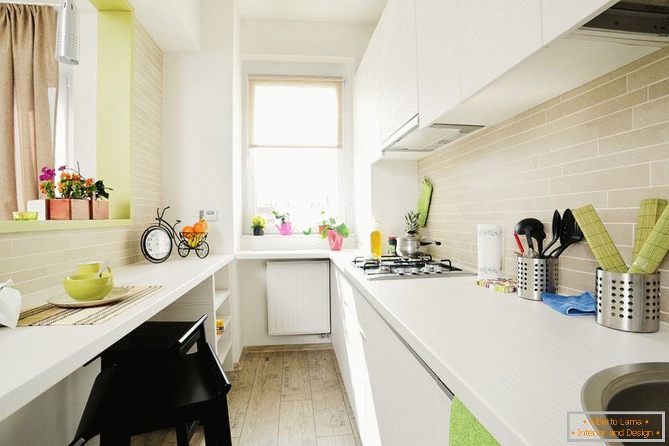 Dlouhá bílá kuchyň se světle zelenými akcenty