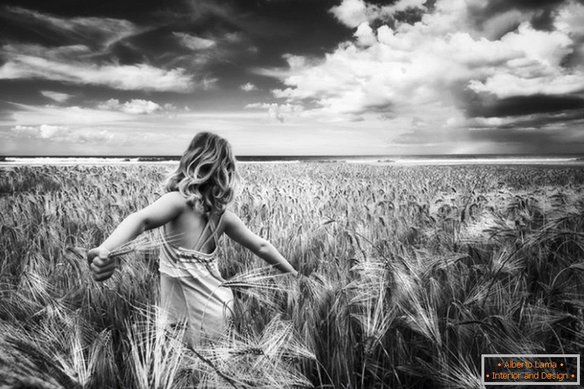 Černá a bílá fotka dívky v pšeničném poli